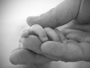 Parent holding baby hand